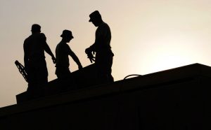 Construction Workers on the Roof of a House